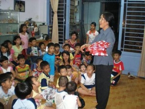 The mother, Miss Cu is giving out the gifts to the orphans.