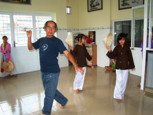 1. Thầy giáo đang dạy các em gái những điệu múa truyền thống của Việt Nam.