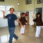 A dance teacher is teaching the girls some traditional Vietnamese dance.